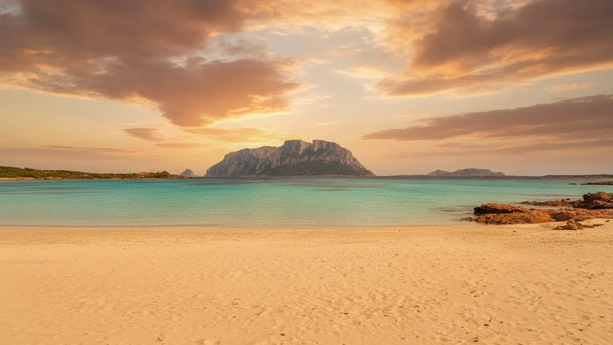 La spiaggia di Porto Istana al tramonto, con il mare turchese e l'isola di Tavolara di fronte